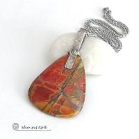 This one-of-a-kind necklace features a large stunning red creek jasper stone accented with a handcrafted sterling silver bail. The stone has a natural pattern in beautiful earthy shades of brick red, orange and green with subtle hints of golden yellow. Big and bold, this necklace is a real statement piece - perfect for anyone that loves natural stones!