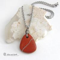 Simple and earthy - this pendant necklace features a natural red jasper gemstone with a wire wrapped sterling silver bail. The stone has a brick red hue with a natural matrix of beige streaks and dots. It has a modern minimalist appeal and is perfect for those that prefer simple, earthy jewelry that coordinates well with all wardrobe styles. It makes a great gift for a natural stone lover - or a nice addition to your own jewelry wardrobe. Handmade in the USA by Silver and Earth Jewelry. 
