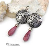 These handmade sterling silver earrings have a modern, classic design that will always be in fashion. They feature natural rhodonite gemstones dangling from textured sterling silver. The stones have a slender teardrop shape and a dark rosy pink hue with subtle brown inclusions. They are accented with tiny pewter beads. Perfect for all occasions -- they'll look great dressed up or down.