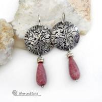 These handmade sterling silver earrings have a modern, classic design that will always be in fashion. They feature natural rhodonite gemstones dangling from textured sterling silver. The stones have a slender teardrop shape and a dark rosy pink hue with subtle brown inclusions. They are accented with tiny pewter beads. Perfect for all occasions -- they'll look great dressed up or down.