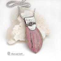 This one-of-a-kind necklace features a large gorgeous rhodonite gemstone accented with a handcrafted sterling silver bail. The stone has a beautiful pink hue with a natural matrix pattern of black, white and tan lines. Coordinating earrings sold separately. Makes a great gift for a natural stone lover - or a nice addition to 