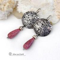 These handmade sterling silver earrings have a modern, classic design that will always be in fashion. They feature natural rhodonite gemstones dangling from textured sterling silver. The stones have a slender teardrop shape and a dark rosy pink hue with subtle brown inclusions. They are accented with tiny pewter beads. Perfect for all occasions -- they'll look great dressed up or down.