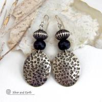 These sterling silver earrings have an earthy, southwestern tribal style. They feature hand textured sterling silver dangles accented with black buffalo horn and Native Navajo pearl style sterling silver beads with a rich, corrugated texture. Unique and striking, they'll make a bold statement. Handmade in the USA by Silver and Earth Jewelry. 