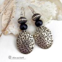 These sterling silver earrings have an earthy, southwestern tribal style. They feature hand textured sterling silver dangles accented with black buffalo horn and Native Navajo pearl style sterling silver beads with a rich, corrugated texture. Unique and striking, they'll make a bold statement. Handmade in the USA by Silver and Earth Jewelry. 
