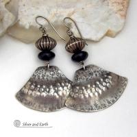 These handcrafted sterling silver earrings have a modern southwestern flair. The sterling shapes have a hammered and stamped texture with an oxidized finish. They are accented with Native Navajo pearl style oxidized sterling silver beads with a rich, corrugated texture and matte black glass beads. Unique and striking, they'll make a bold statement. Handmade in the USA by Silver and Earth Jewelry.