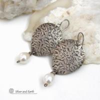 Perfect for everyday wear, these handcrafted sterling silver earrings are accented with dangling white freshwater pearls. The silver has an intricate hand stamped texture with an oxidized finish. The pearls contrast beautifully against the silver metal. They have an elegant, feminine feel with a contemporary design that looks great with all wardrobe styles. They'll make a great gift for someone born in June. Pearl is the traditional gemstone for this month. Handmade in the USA by Silver and Earth Jewelry. 