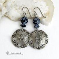 These handcrafted earrings have a modern bold edgy vibe. They feature rustic hammered and hand stamped silver tone pewter dangles accented with natural snowflake obsidian gemstones. The stones have a natural pattern in hues of black and soft gray. This stone is a natural volcanic glass which contains the mineral cristobalite - which creates the "snowflake" type patterns. Bold and striking - they're sure to make a statement. Perfect for women that love natural stones and unique artisan handmade jewelry. 