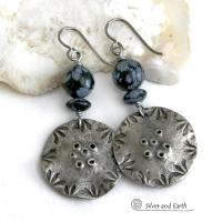 These handcrafted earrings have a modern bold edgy vibe. They feature rustic hammered and hand stamped silver tone pewter dangles accented with natural snowflake obsidian gemstones. The stones have a natural pattern in hues of black and soft gray. This stone is a natural volcanic glass which contains the mineral cristobalite - which creates the "snowflake" type patterns. Bold and striking - they're sure to make a statement. Perfect for women that love natural stones and unique artisan handmade jewelry. 