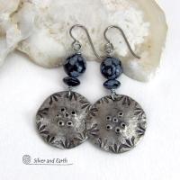 These handcrafted earrings have a modern bold edgy vibe. They feature rustic hammered and hand stamped silver tone pewter dangles accented with natural snowflake obsidian gemstones. The stones have a natural pattern in hues of black and soft gray. This stone is a natural volcanic glass which contains the mineral cristobalite - which creates the "snowflake" type patterns. Bold and striking - they're sure to make a statement. Perfect for women that love natural stones and unique artisan handmade jewelry. 