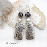 These handcrafted sterling silver earrings have a hand stamped and lightly hammered organic texture and are accented with natural sunstone / moonstone gemstones and mother of pearl and small stainless steel beads. This hybrid stone is rare and found only in Tanzania. It has beautiful shimmery hues of black with natural silvery flashes and subtle peach and gold inclusions. These earrings have a modern, elegant chic style that looks great dressed up or down. Perfect for women that love unique gemstone jewelry