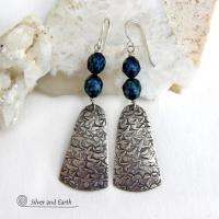 These sterling silver earrings feature handcrafted sterling silver dangles with an intricate hand stamped texture accented with deep teal blue freshwater pearls with a faceted finish.  They have a modern, elegant feel and will look great dressed up or down. They dangle from sterling silver ear wires. Handmade in the USA by Silver and Earth Jewelry. 
