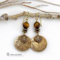 These handcrafted earrings feature gold brass dangles with a lightly hammered texture accented with natural tiger's eye gemstones, brass leaf charms and faceted hematite stones with a sparkly electroplated gold tone finish. The tiger's eye stones also have a faceted cut which casts off a beautiful natural sparkle and shine. They have a modern, elegant chic style that coordinates with all wardrobe styles. Makes a great gift for a nature lover - or a nice addition to your own jewelry wardrobe. 