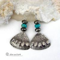 These handcrafted sterling silver earrings feature a unique hand textured design and are accented with natural turquoise and metallic gray pyrite stones. They have a southwestern boho tribal flair and will make a striking statement. The pyrite stones add a touch of natural sparkle and shine. Handmade in the USA by Silver and Earth Jewelry. 