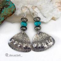 These handcrafted sterling silver earrings feature a unique hand textured design and are accented with natural turquoise and metallic gray pyrite stones. They have a southwestern boho tribal flair and will make a striking statement. The pyrite stones add a touch of natural sparkle and shine. Handmade in the USA by Silver and Earth Jewelry. 