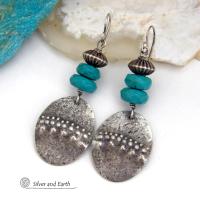 These handcrafted earrings feature sterling silver oval dangles with a hammered and hand stamped texture accented with faceted natural turquoise gemstones and oxidized sterling silver beads with a rich, corrugated texture and oxidized finish. They have a modern, southwestern style and are perfect for women that love to wear artisan handcrafted southwestern jewelry. Handmade in the USA by Silver and Earth jewelry, a New Mexico True Certified business. 