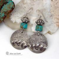 These handcrafted earrings feature uniquely textured hammered and hand stamped sterling silver accented with natural turquoise stones and silver plated beads. Bold and striking, they have a modern, southwest style with a touch of tribal flair. Handmade in the USA by Silver and Earth Jewelry. 
