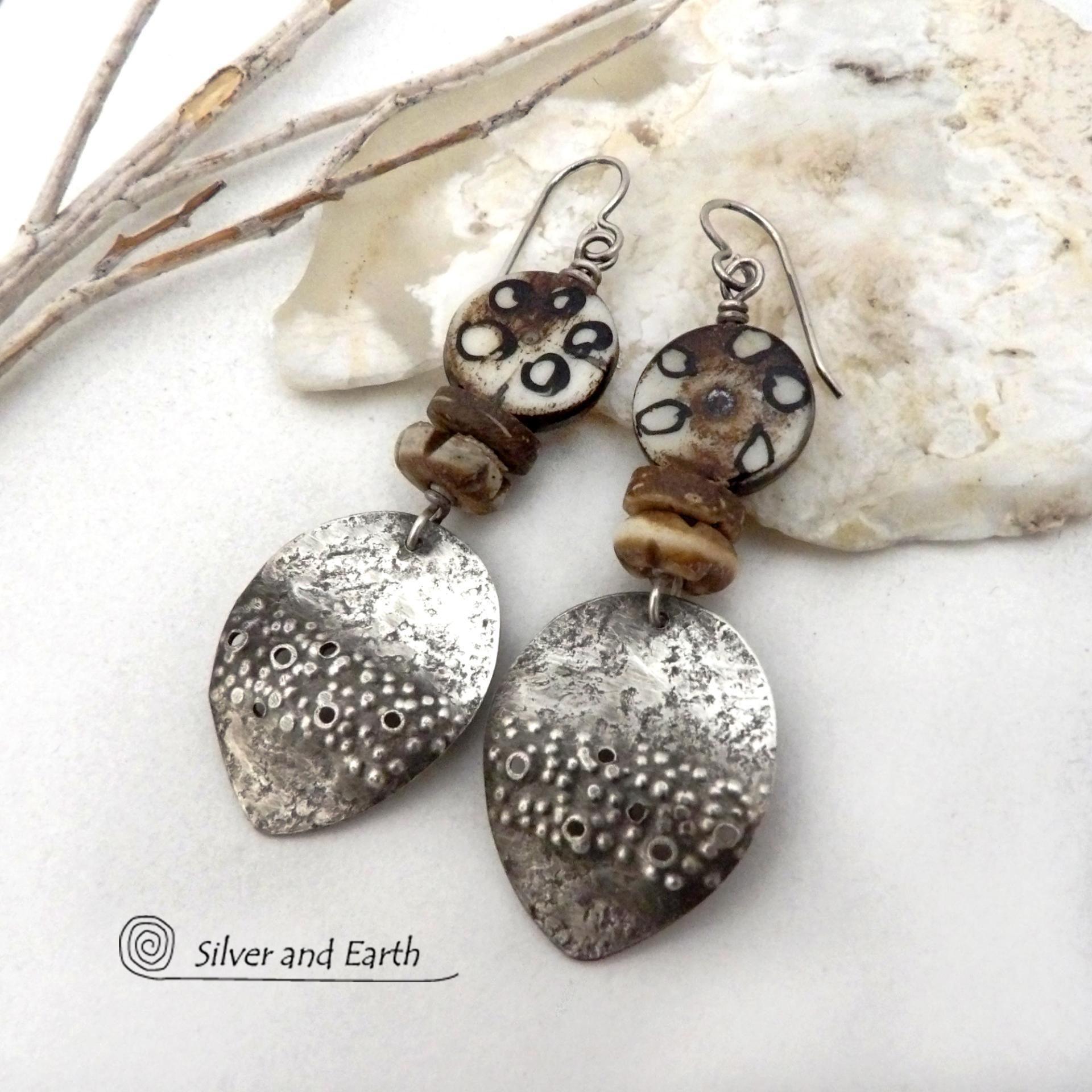 Bold and striking, these handcrafted sterling silver earrings have a funky edgy vibe with ethnic African style tribal flair. They feature rustic hammered sterling silver dangles accented with African batik, bone and brown coconut shell beads. Bold and exotic, they'll add a touch a bohemian tribal style to your wardrobe that is sure to make a statement.