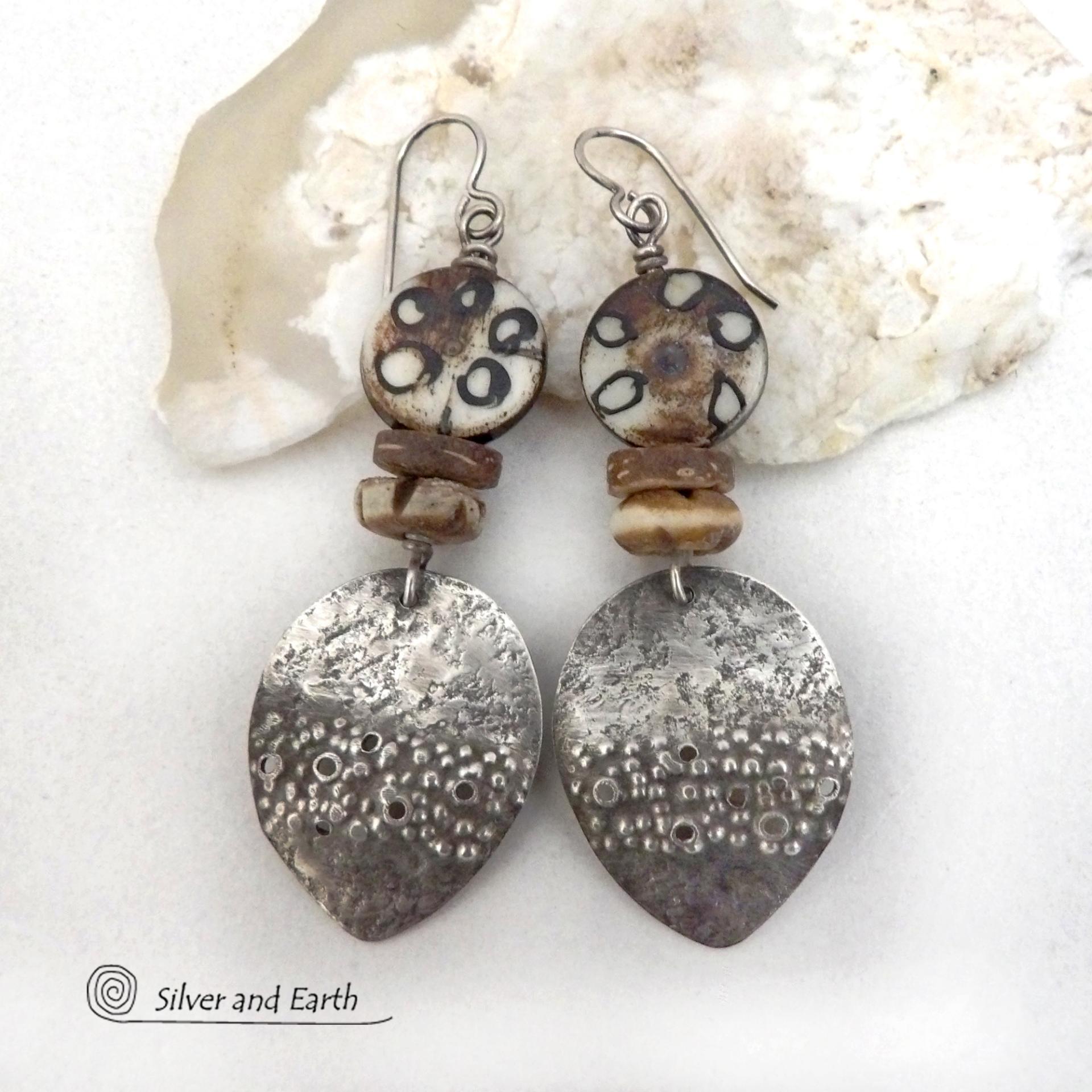 Unique and one of a kind, these handcrafted sterling silver earrings have a funky edgy vibe with ethnic tribal flair. They feature rustic hammered sterling silver dangles accented with African batik, bone and brown coconut shell beads. Bold and exotic, they'll add a touch a bohemian tribal style to your wardrobe that is sure to make a statement.