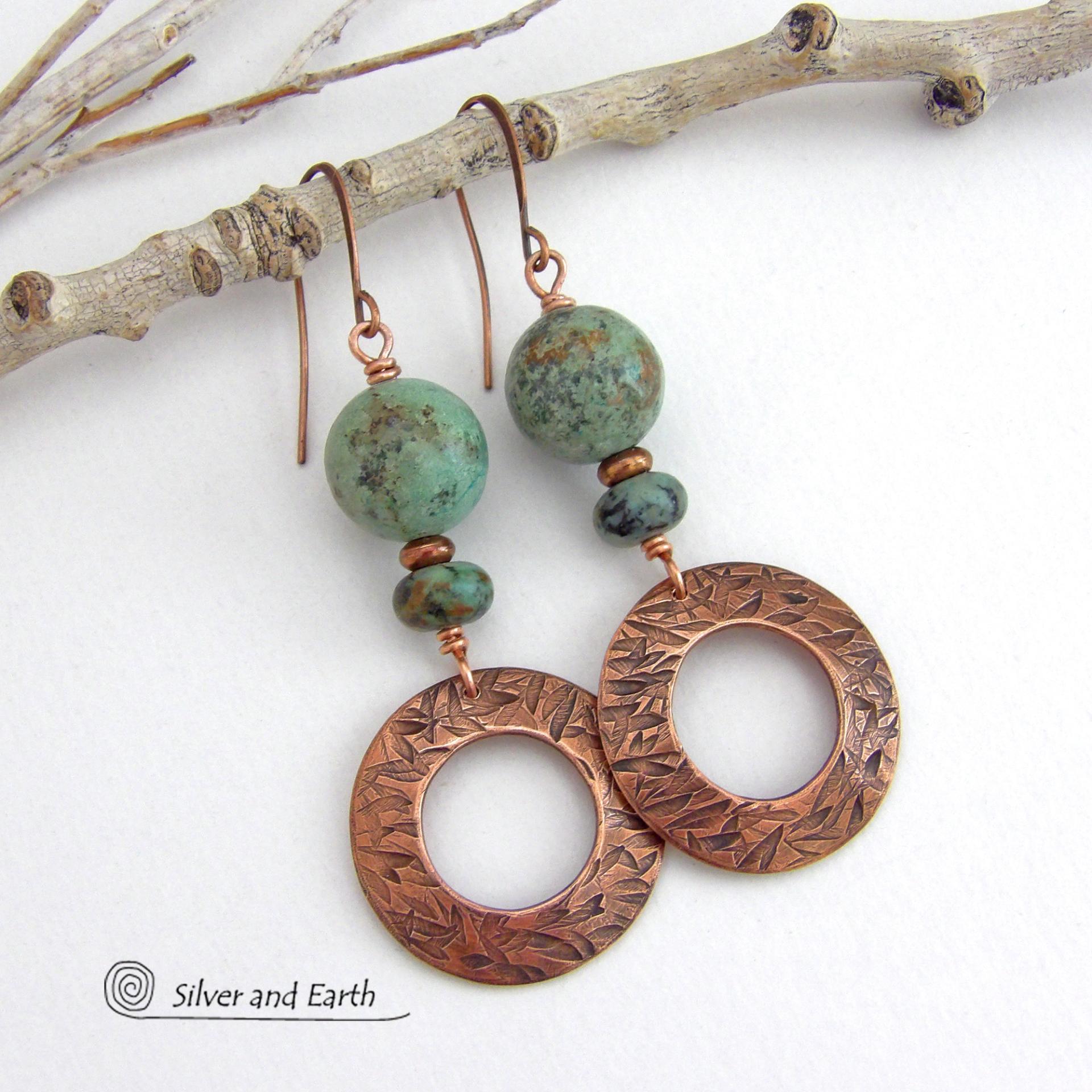  These handcrafted earrings feature round copper hoop dangles with a hand stamped texture accented with a stack of natural African turquoise stones and tiny copper beads. The stones have a pretty turquoise hue with an earthy natural black and brown matrix. These earrings have an earthy chic style with a modern bohemian flair that will coordinate beautifully with all wardrobe types. Handmade in the USA by Silver and Earth Jewelry.  Your choice of ear wires - copper or hypoallergenic niobium. 