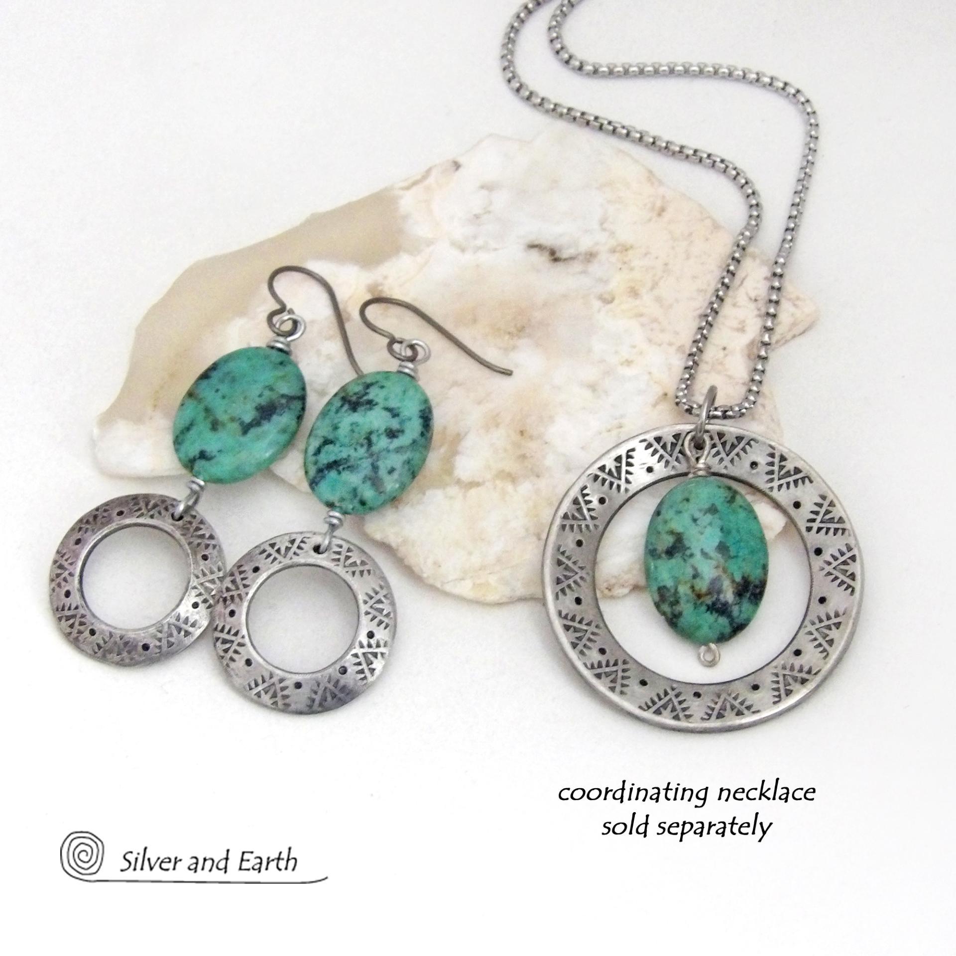 These handcrafted earrings feature natural African turquoise stones accented with silver tone pewter dangles with a hand stamped texture and oxidized finish. They have an earthy, modern style with a touch of southwestern flair. Matching necklace sold separately. Handmade in the USA by Silver and Earth Jewelry. 