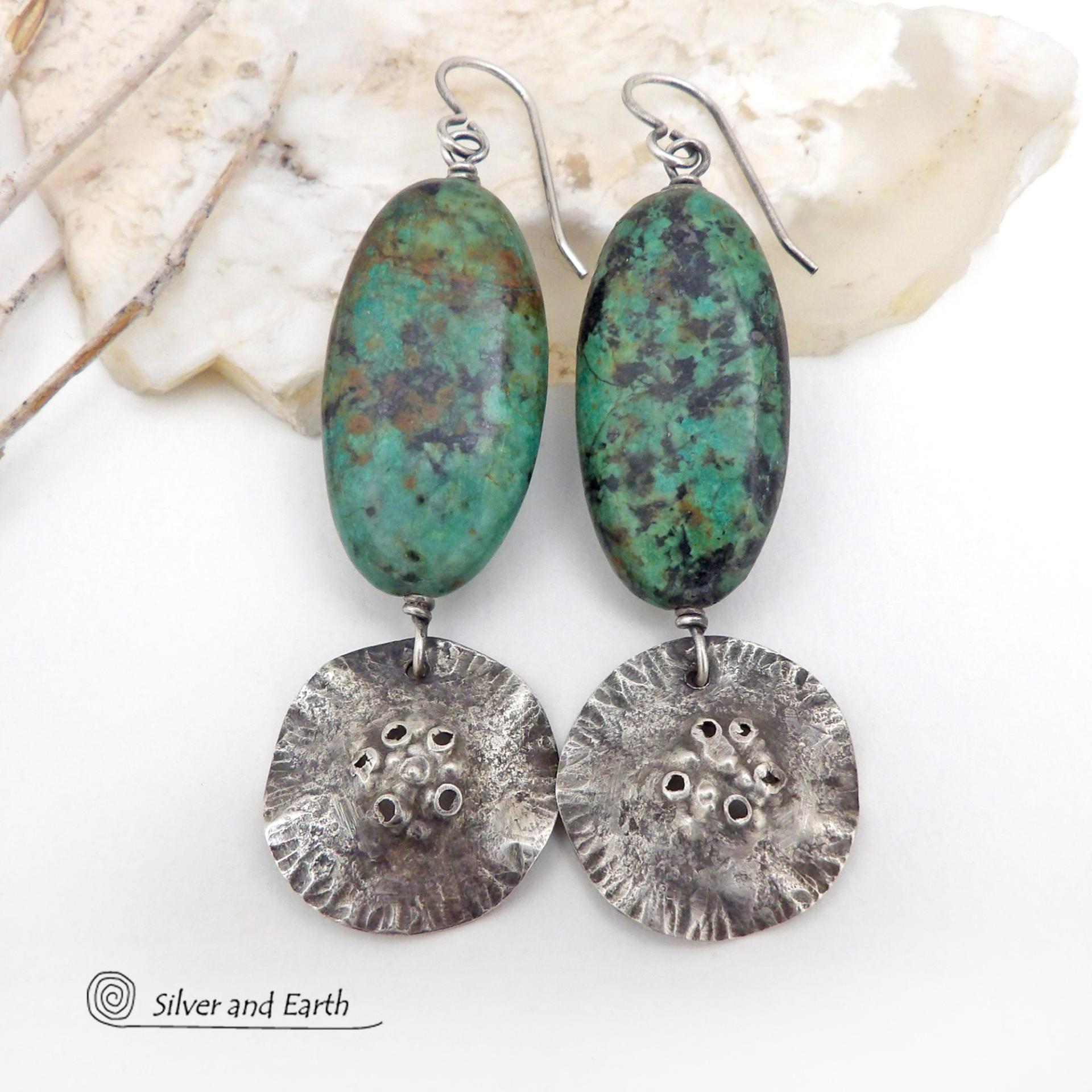 Big, long natural African turquoise stones are accented with rustic hammered sterling silver dangles in these one-of-a-kind earrings. They have an earthy, organic style and are perfect for anyone that loves natural stones and unique handcrafted artisan jewelry. I hand sawed the dangles out of solid sterling silver sheet; hammered them for texture; crimped the edges for a ruffled effect; then added a few holes for a rustic vibe. Handmade in the USA by Silver and Earth Jewelry.