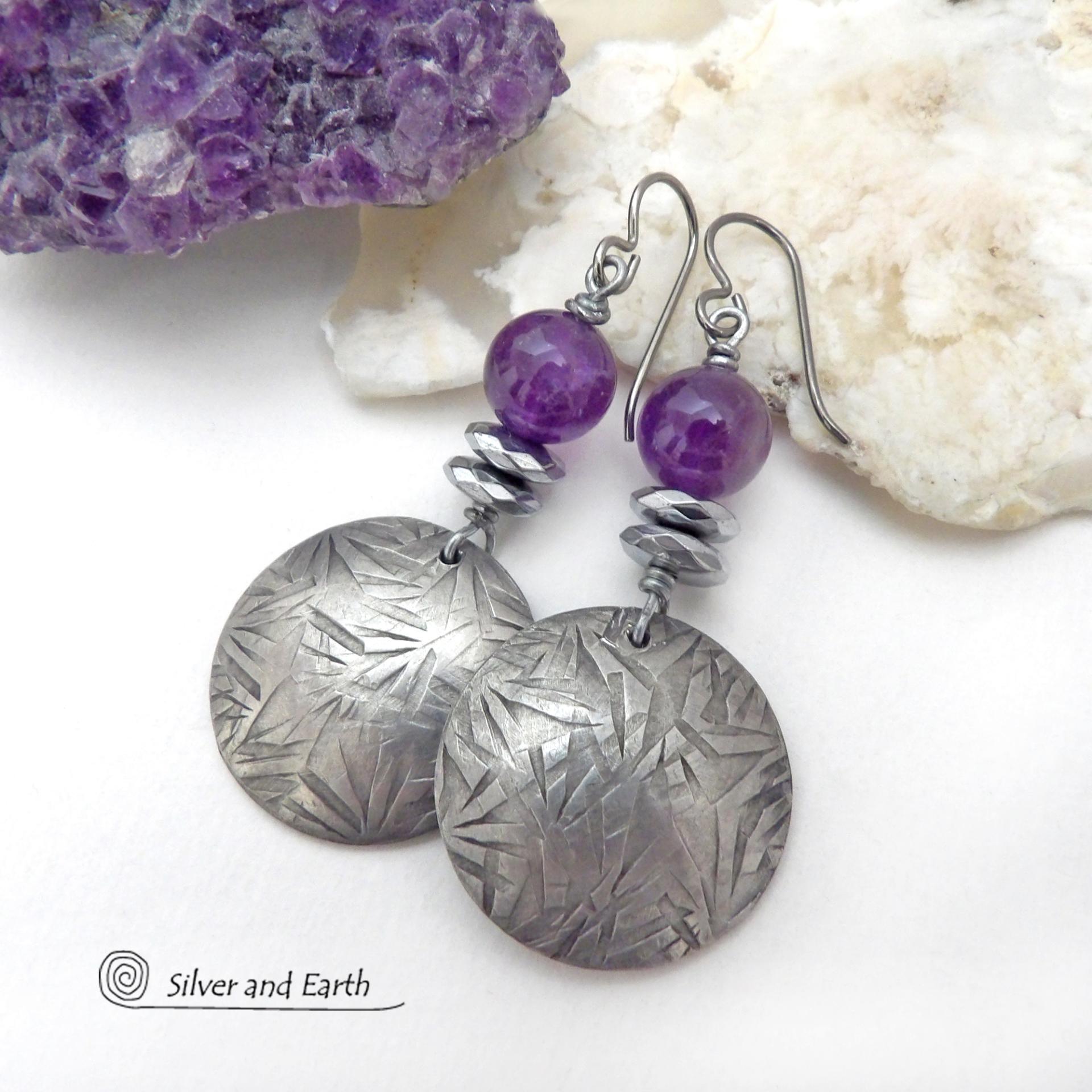 These handcrafted round silver pewter earrings have a hand stamped texture and are accented with purple amethyst and faceted hematite gemstones. The hematite has a natural sparkle and shine which gives these earrings an elegant, modern chic style that will look great dressed up or down. They'll coordinate beautifully with all wardrobe styles. Makes a great gift for someone with a February birthday - amethyst is that month's birthstone. Handmade in the USA by Silver and Earth Jewelry.