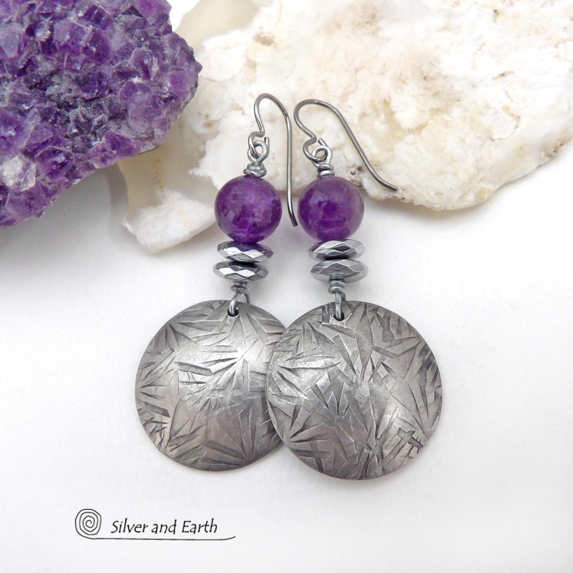 These handcrafted round silver pewter earrings have a hand stamped texture and are accented with purple amethyst and faceted hematite gemstones. The hematite has a natural sparkle and shine which gives these earrings an elegant, modern chic style that will look great dressed up or down. They'll coordinate beautifully with all wardrobe styles. Makes a great gift for someone with a February birthday - amethyst is that month's birthstone. Handmade in the USA by Silver and Earth Jewelry.