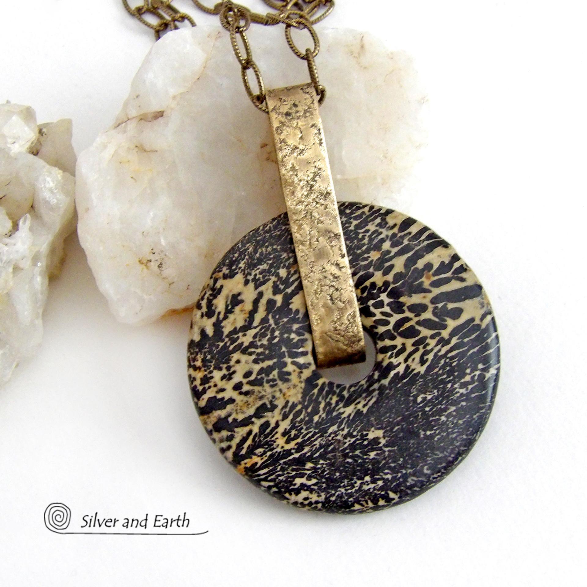 This one-of-a-kind pendant necklace features a stunning artistic jasper stone accented with a hand forged gold brass bail. This type of jasper is known for its intricate, natural patterns that resemble brushstrokes, landscapes, or abstract art. The stone in this piece has a natural bold dramatic pattern in hues of black and soft golden yellow with black streaks that resemble "feathery" dendrites. The design is modern and bold - yet classic and always in fashion. It can be worn by either a man or women. 