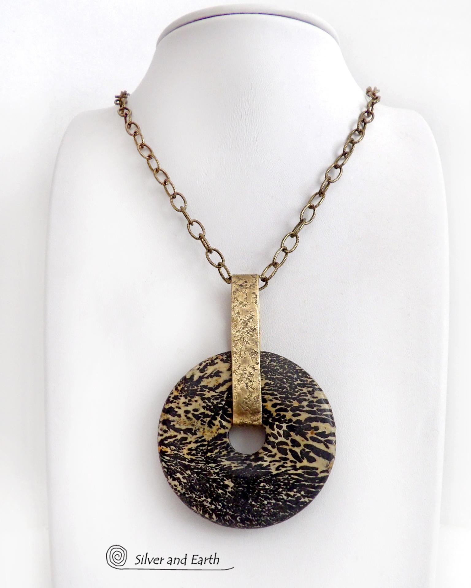 This one-of-a-kind pendant necklace features a stunning artistic jasper stone accented with a hand forged gold brass bail. This type of jasper is known for its intricate, natural patterns that resemble brushstrokes, landscapes, or abstract art. The stone in this piece has a natural bold dramatic pattern in hues of black and soft golden yellow with black streaks that resemble "feathery" dendrites. The design is modern and bold - yet classic and always in fashion. It can be worn by either a man or women. 