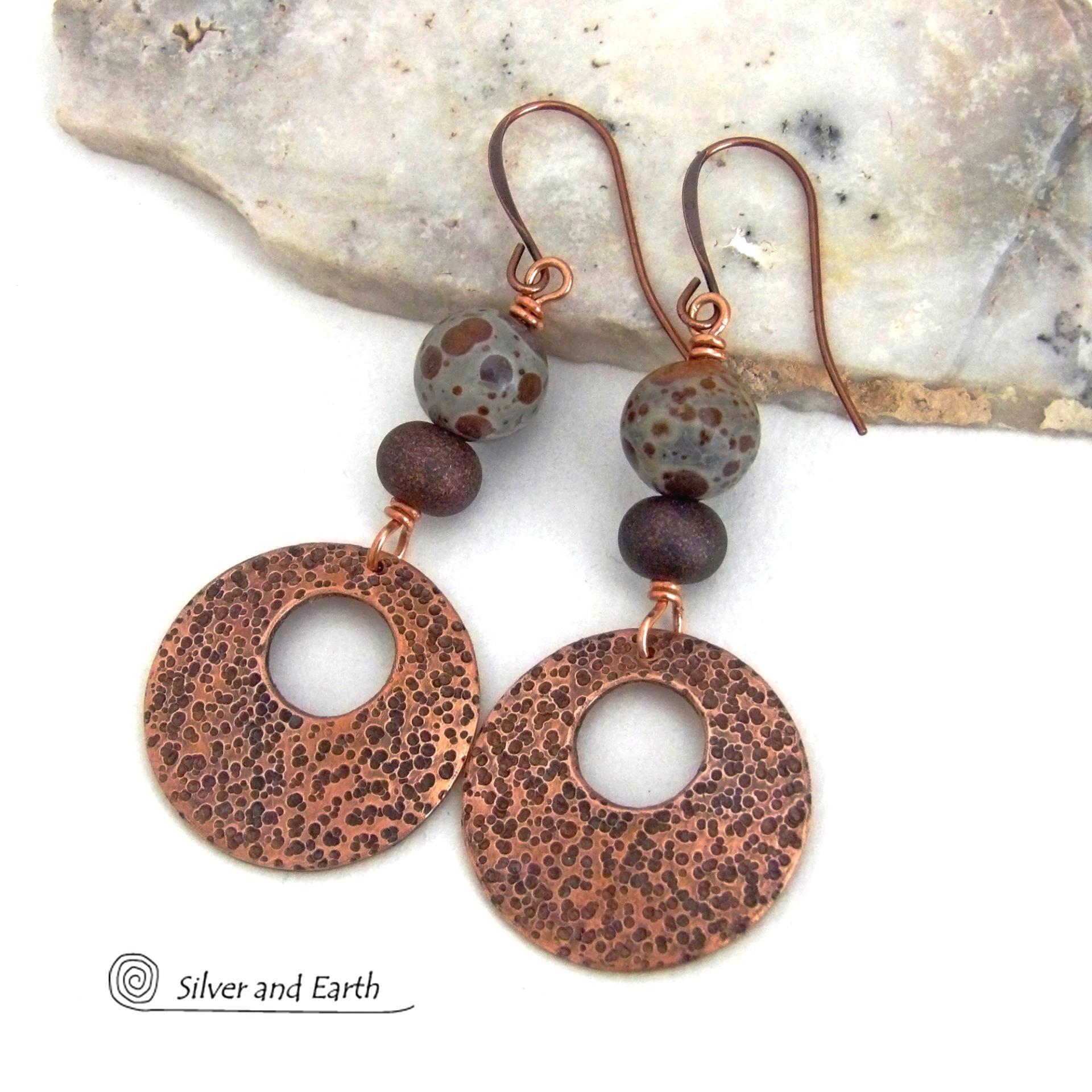 These handcrafted earrings feature round copper hoop dangles with a rustic hand stamped texture accented with natural spotted asteroid jasper and bronze glass beads. Unique and striking, they have an earthy organic flair that makes a bold statement. The jasper stones have a great natural spotted pattern with earthy shades of chocolate brown and grey. Your choice of ear wires - copper or hypoallergenic niobium.