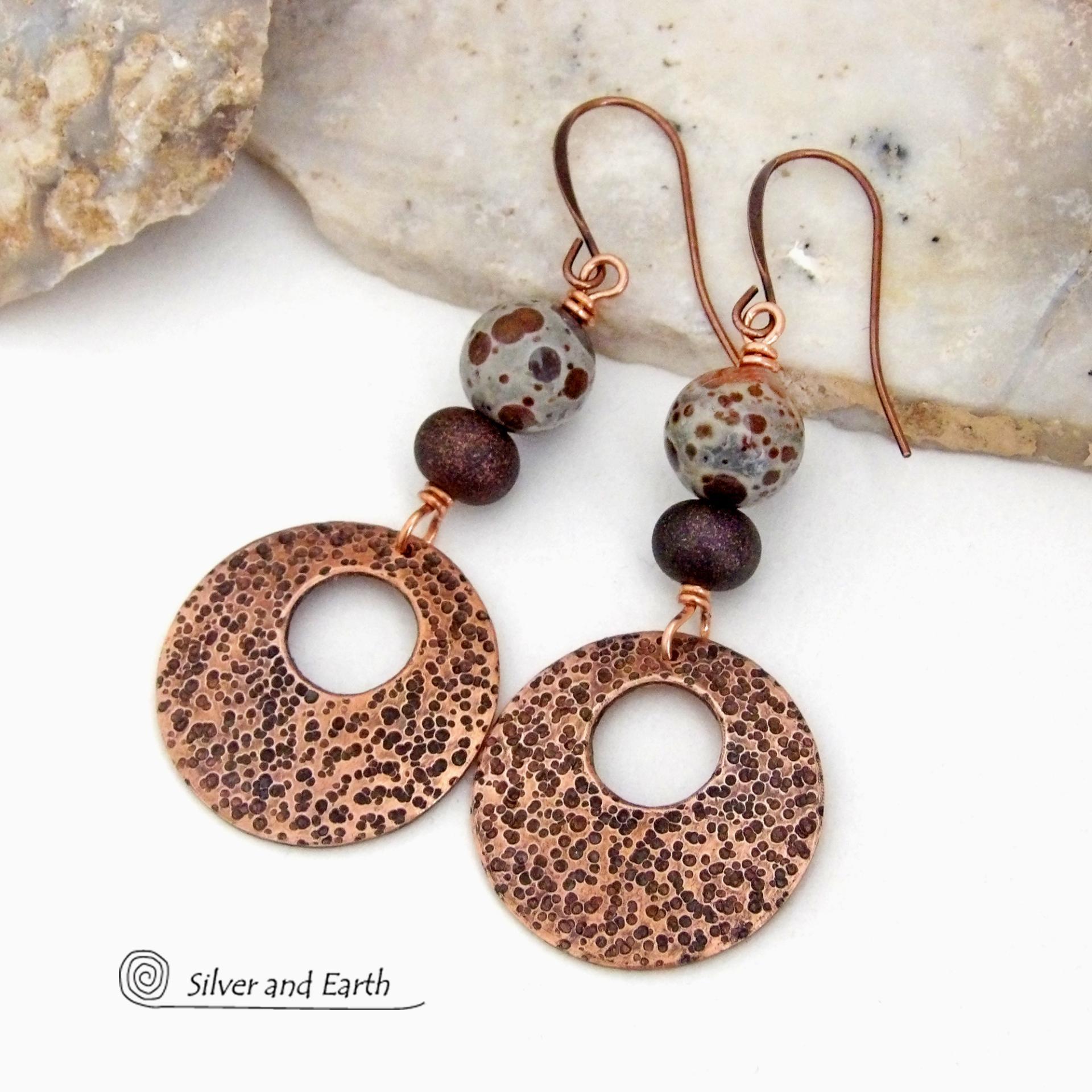 These handcrafted earrings feature round copper hoop dangles with a rustic hand stamped texture accented with natural spotted asteroid jasper and bronze glass beads. Unique and striking, they have an earthy organic flair that makes a bold statement. The jasper stones have a great natural spotted pattern with earthy shades of chocolate brown and grey. Your choice of ear wires - copper or hypoallergenic niobium.