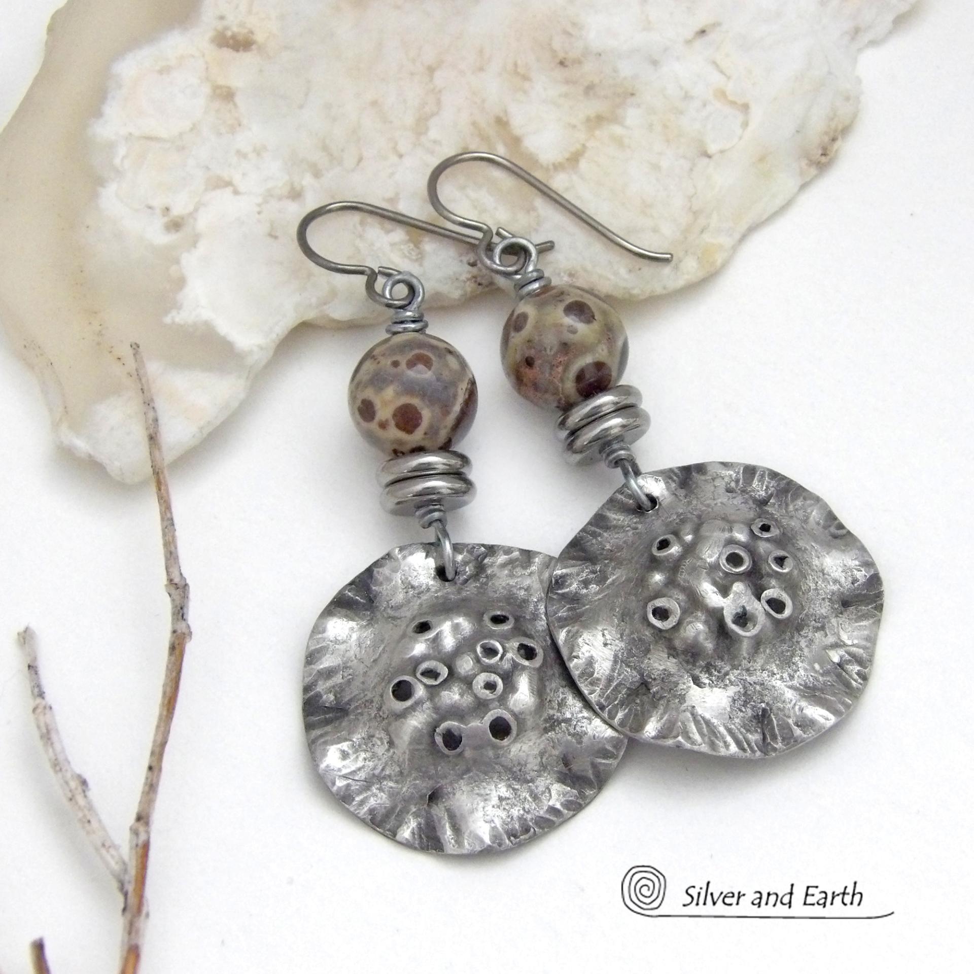 These handcrafted earrings have a bold edgy vibe. They feature rustic hammered silver tone pewter dangles accented with natural asteroid jasper stones and stainless steel beads. This type of stone is known for its unique dotted matrix in earth-tone hues of brown, gray and tan. Bold and striking - they're sure to make a statement. Perfect for women that love unique natural stones and artisan handmade jewelry. Handmade in the USA by Silver and Earth Jewelry. 