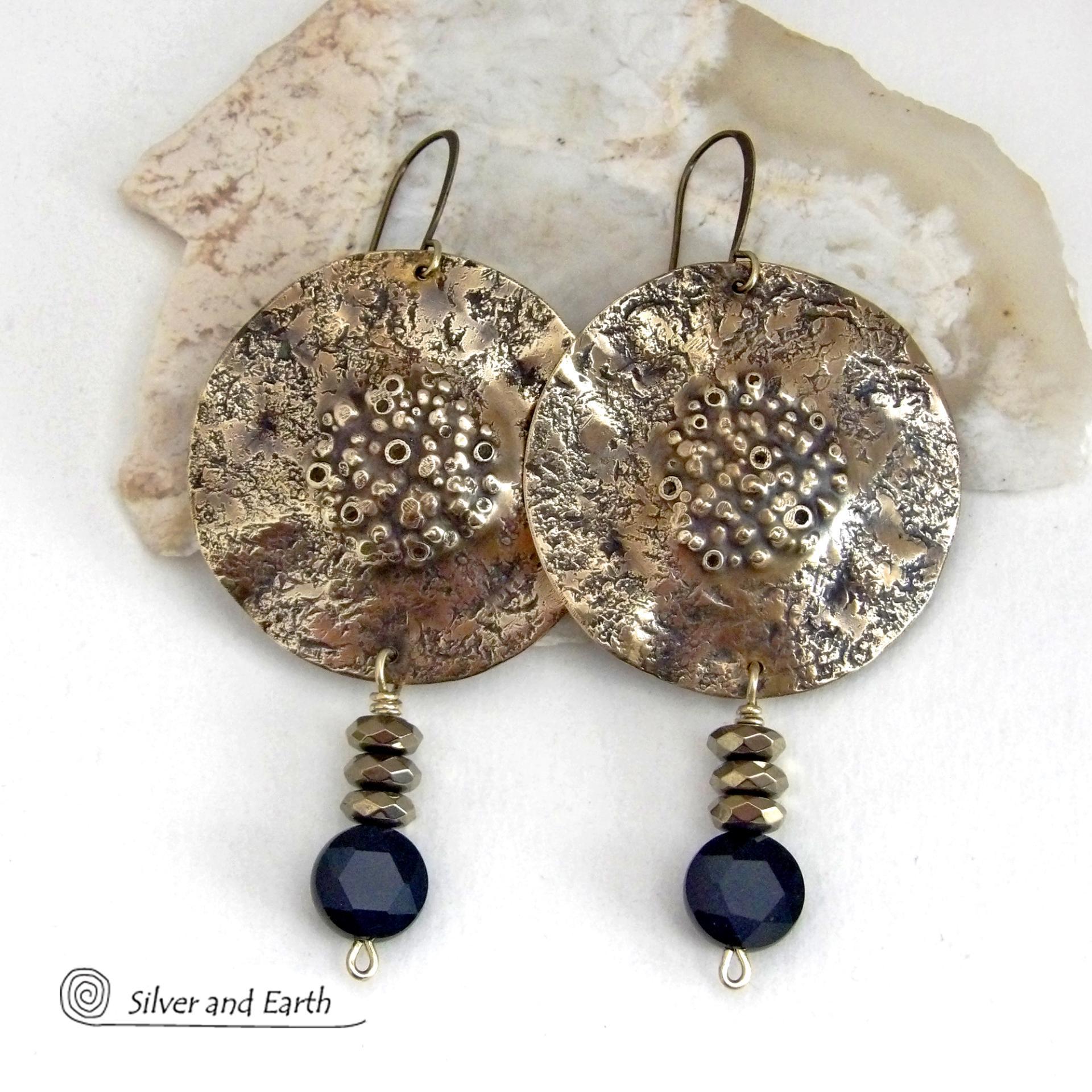 Big and bold - these handcrafted gold brass earrings have a modern chic contemporary style with an earthy, organic vibe that makes a striking statement. They feature large brass circles with a rustic, organic hand textured design accented with dangling faceted black onyx gemstones and faceted hematite stones with a sparkly electroplated gold tone finish. Unique and striking, they have a modern chic style with an exotic vibe that looks great dressed up or down. 