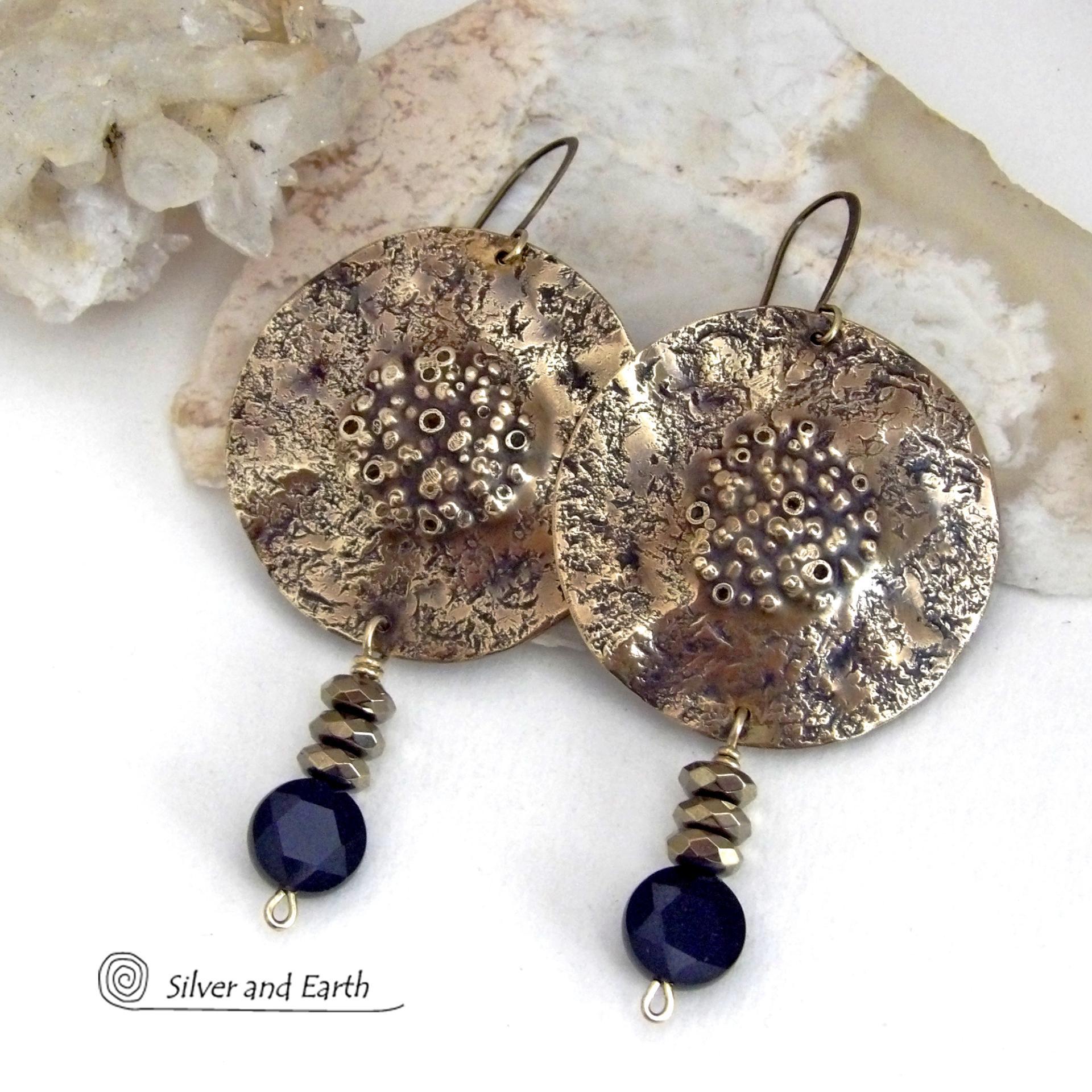 Big and bold - these handcrafted gold brass earrings have a modern chic contemporary style with an earthy, organic vibe that makes a bold, striking statement. They feature large brass circles with a rustic, organic hand textured design accented with dangling faceted black onyx gemstones and faceted hematite stones with a sparkly electroplated gold tone finish. Unique and striking, they have an earthy organic style with an exotic vibe that will look great dressed up or down. 