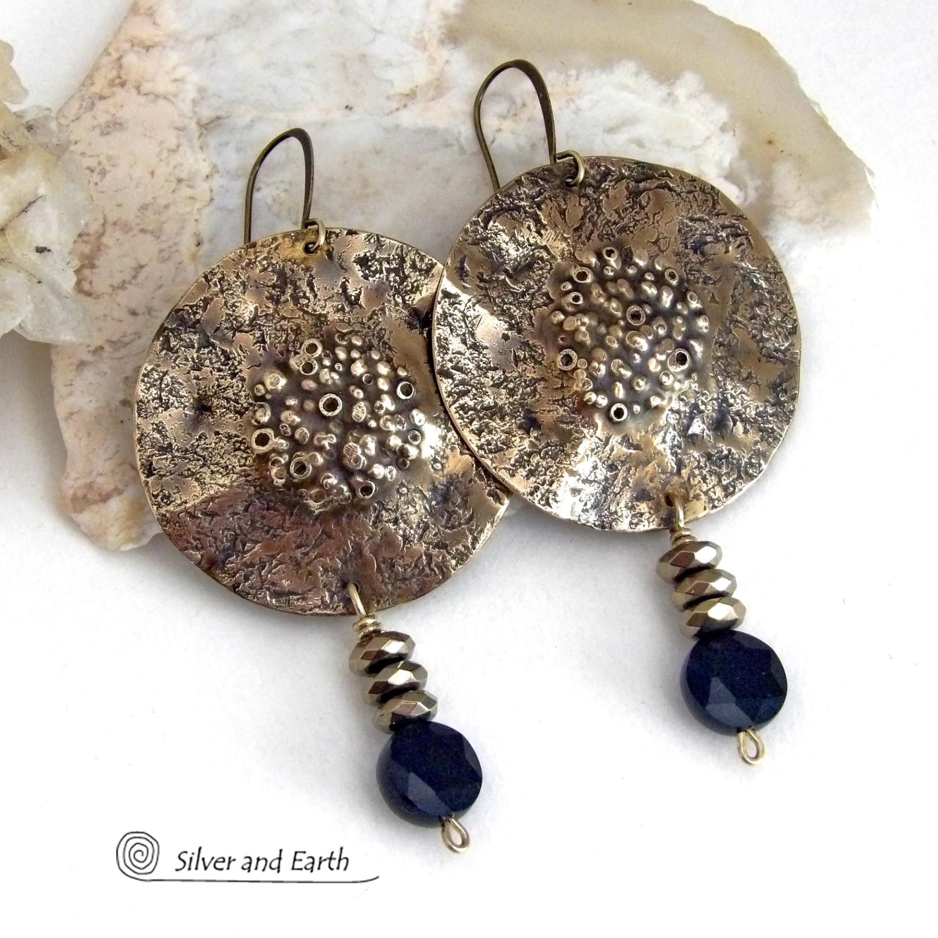 Big and bold - these handcrafted gold brass earrings have a modern chic contemporary style with an earthy, organic vibe that makes a bold, striking statement. They feature large brass circles with a rustic, organic hand textured design accented with dangling faceted black onyx gemstones and faceted hematite stones with a sparkly electroplated gold tone finish. Unique and striking, they have an earthy organic style with an exotic vibe that will look great dressed up or down. 