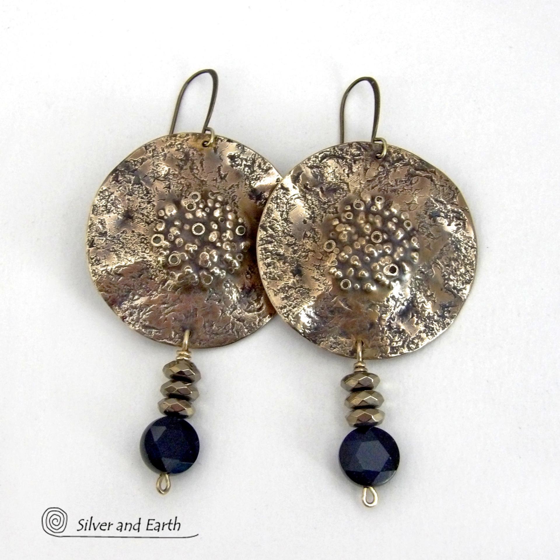 Big and bold - these handcrafted gold brass earrings have a modern chic contemporary style with an earthy, organic vibe that makes a bold, striking statement. They feature large brass circles with a rustic, organic hand textured design accented with dangling faceted black onyx gemstones and faceted hematite stones with a sparkly electroplated gold tone finish. Unique and striking, they have an earthy organic style with an exotic vibe that will look great dressed up or down. 