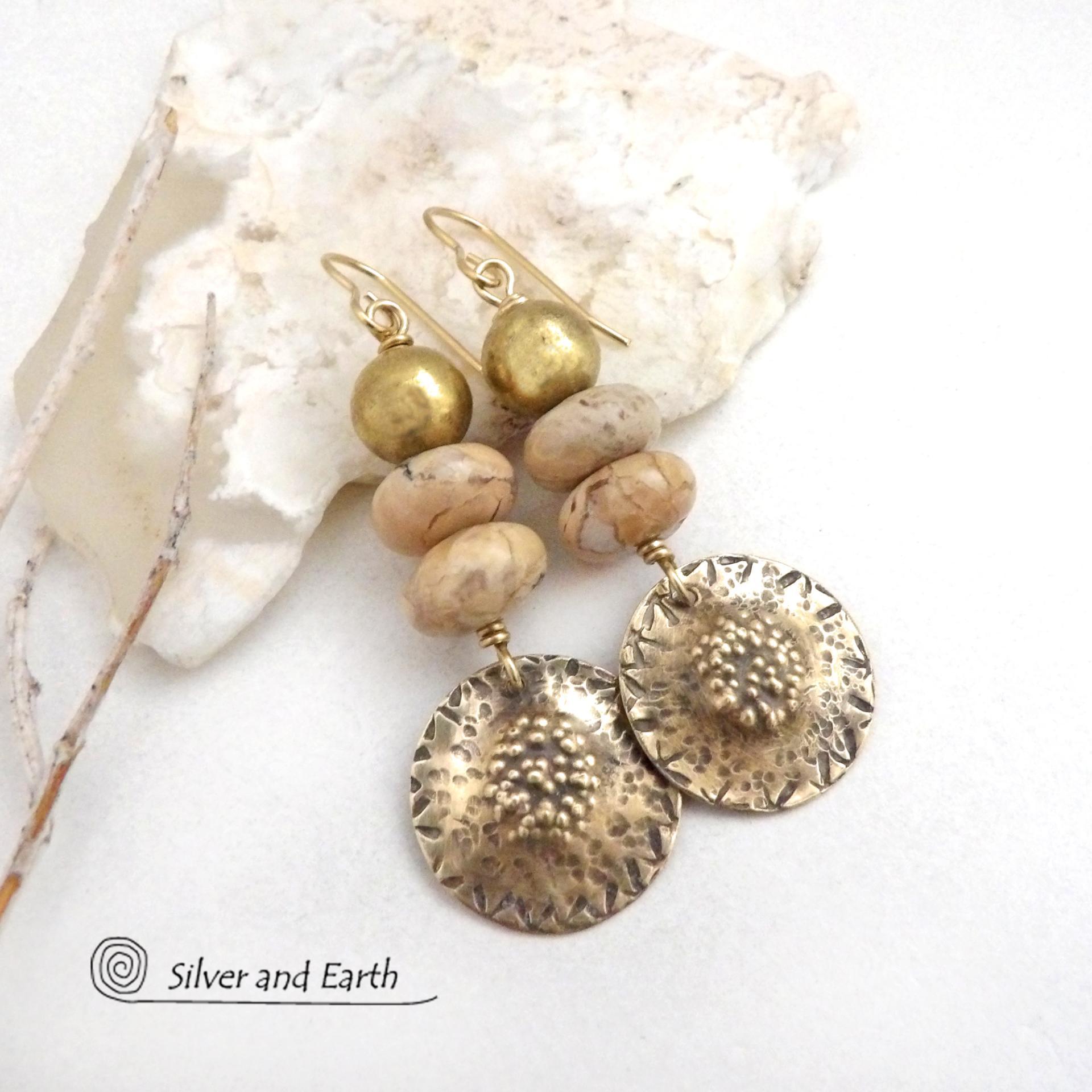Creamy beige agate stones are accented with textured gold brass dangles and brass beads in these handcrafted earrings. The stones have a creamy beige and tan hue with a natural light brown speckled matrix. They have an earthy, modern style that coordinates beautifully with all wardrobe types.These handcrafted earrings showcase a unique blend of textures and patterns, perfect for adding a touch of bohemian style to any outfit. 