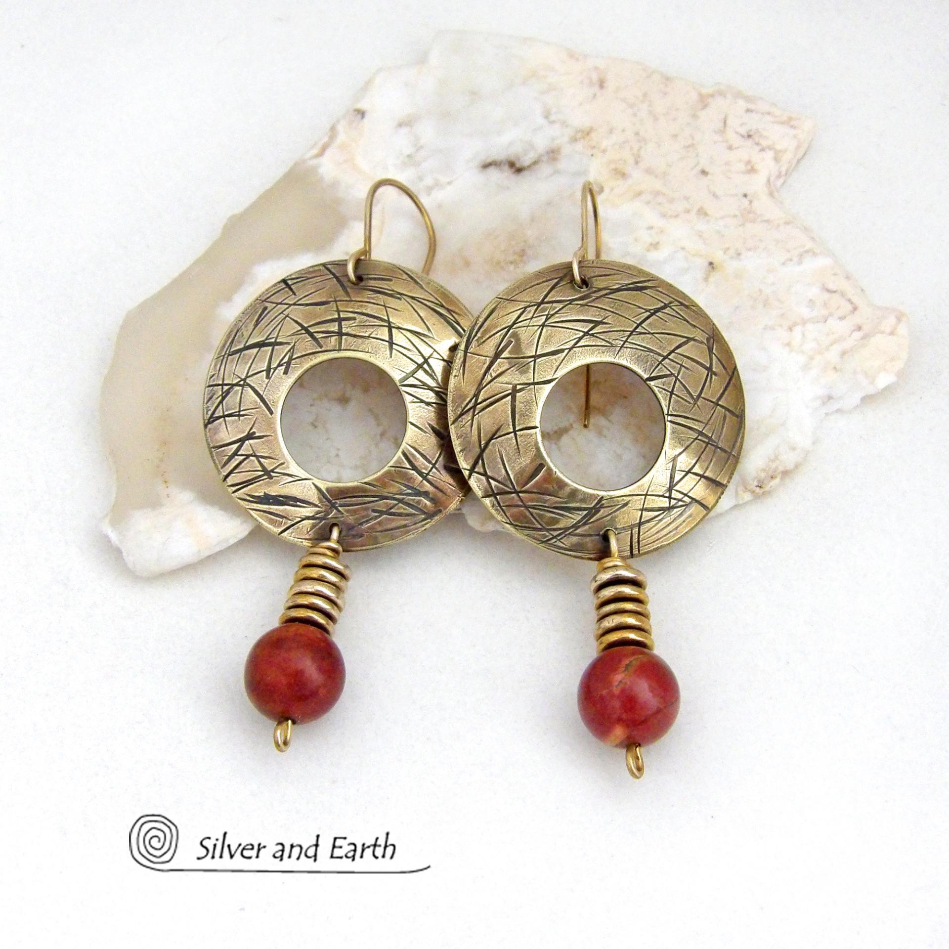 These handcrafted gold brass earrings have a hand stamped texture and are accented with dangling burgundy jasper gemstones and brass beads. Big and bold, they have a modern chic vibe that makes a striking eye-catching statement. Handmade in the USA by Silver and Earth Jewelry. 
