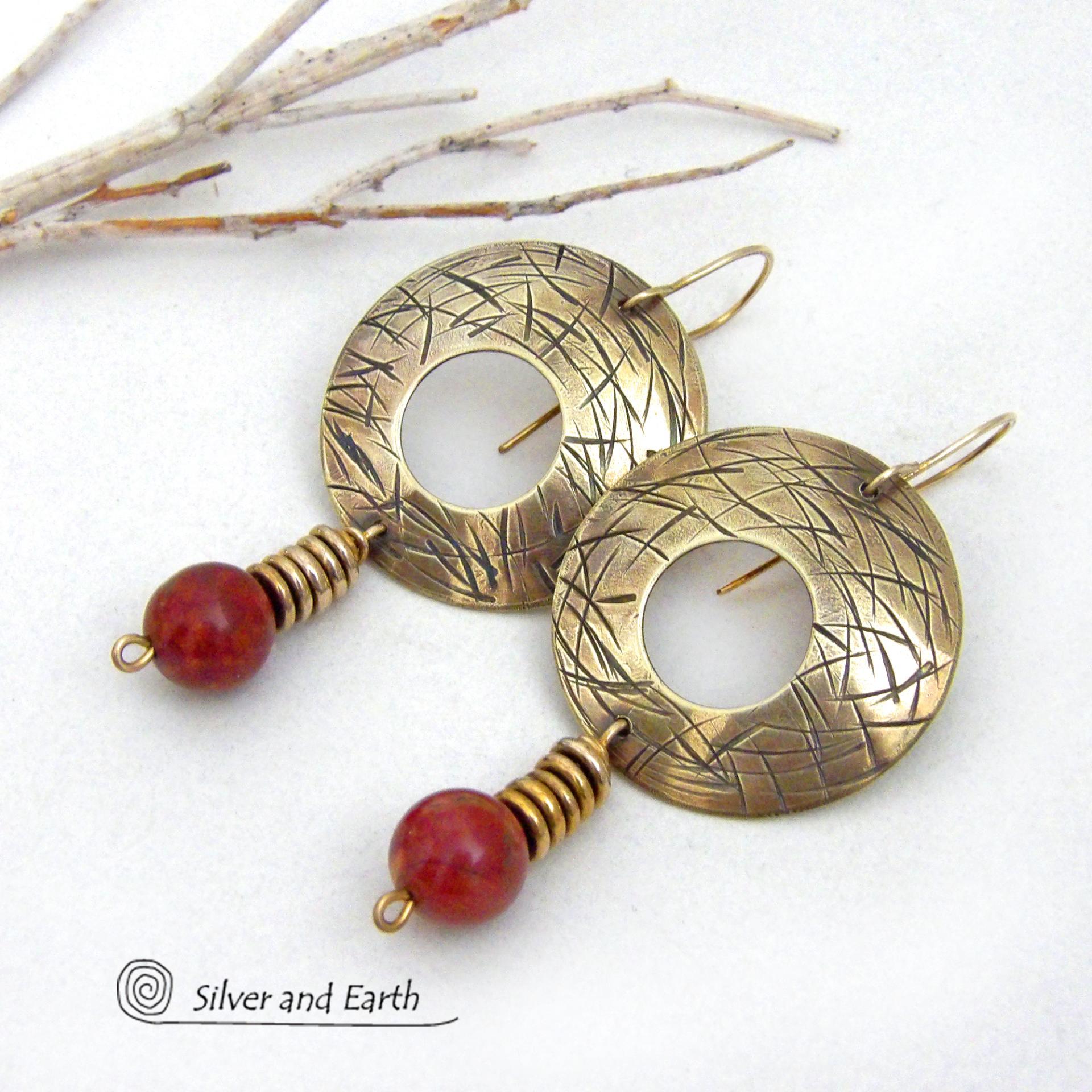These handcrafted gold brass earrings have a hand stamped texture and are accented with dangling burgundy jasper gemstones and brass beads. Big and bold, they have a modern chic vibe that makes a striking eye-catching statement. Handmade in the USA by Silver and Earth Jewelry. 