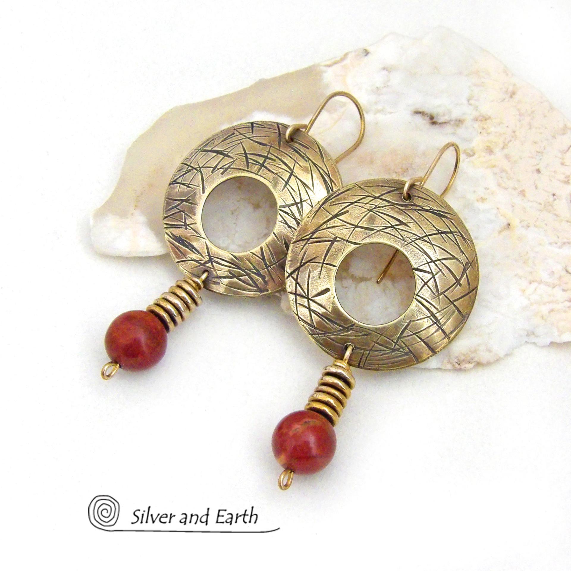 These handcrafted gold brass earrings have a hand stamped texture and are accented with dangling burgundy jasper gemstones and brass beads. Big and bold, they have a modern chic vibe that makes a striking eye-catching statement. Handmade in the USA by Silver and Earth Jewelry. 