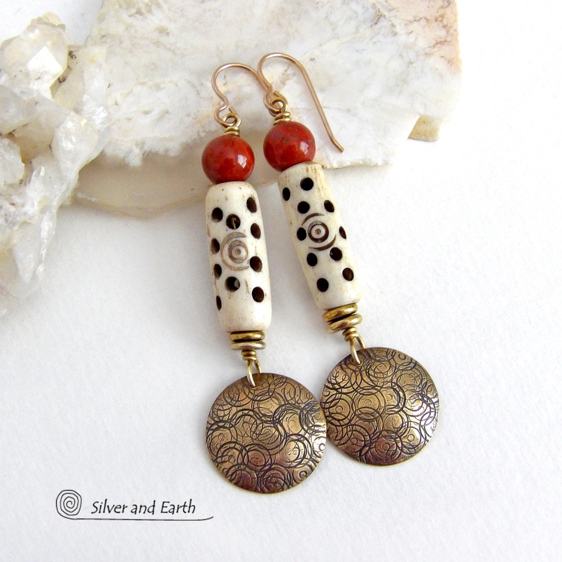 These handcrafted earrings feature a carved African bone beads, red jasper gemstones and textured gold brass dangles. Unique and striking, they have a boho chic style with lots of tribal flair. Perfect for women that love to wear bold unique artisan handmade jewelry. Handmade in the USA by Silver and Earth Jewelry. 