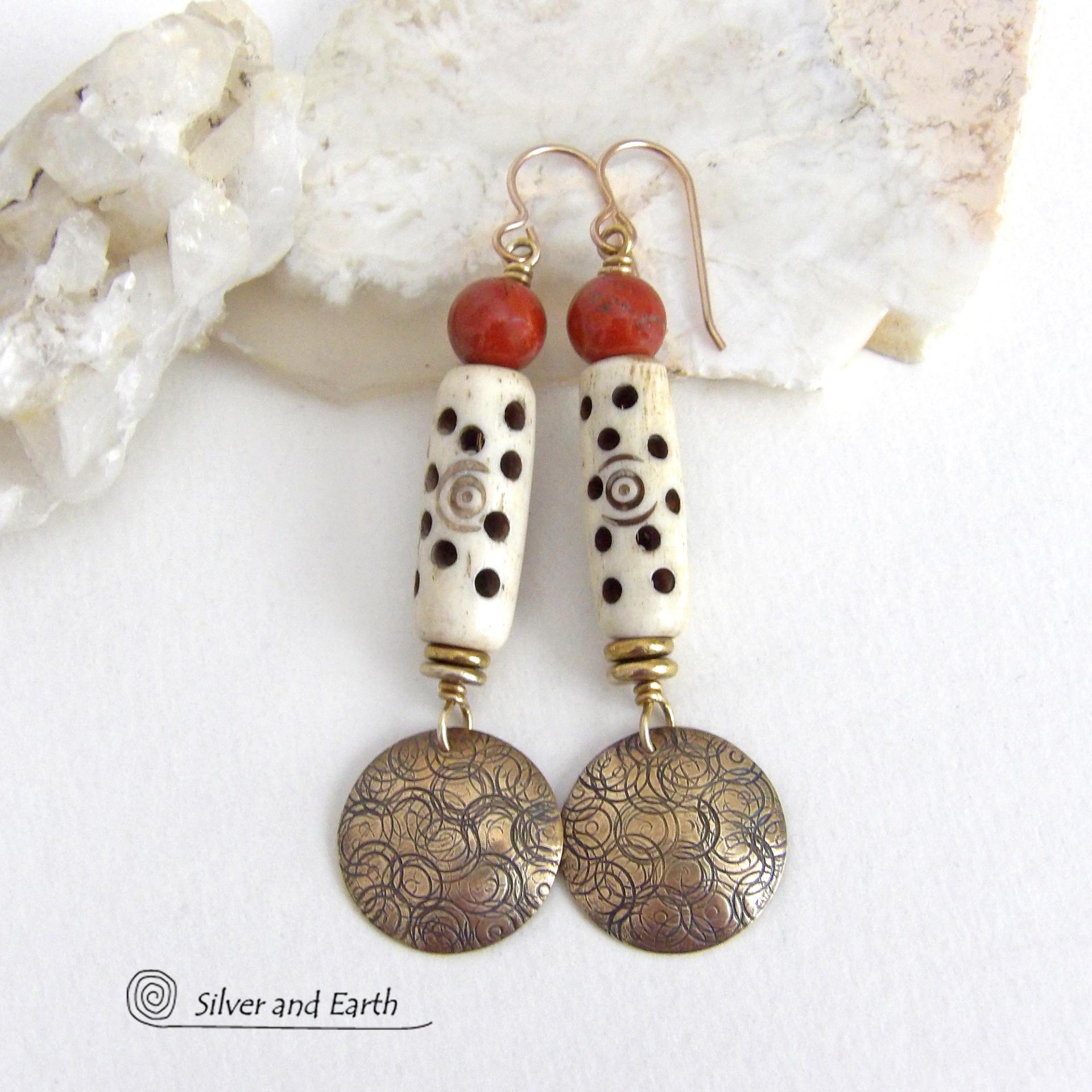 These handcrafted earrings feature a carved African bone beads, red jasper gemstones and textured gold brass dangles. Unique and striking, they have a boho chic style with lots of tribal flair. Perfect for women that love to wear bold unique artisan handmade jewelry. Handmade in the USA by Silver and Earth Jewelry. 