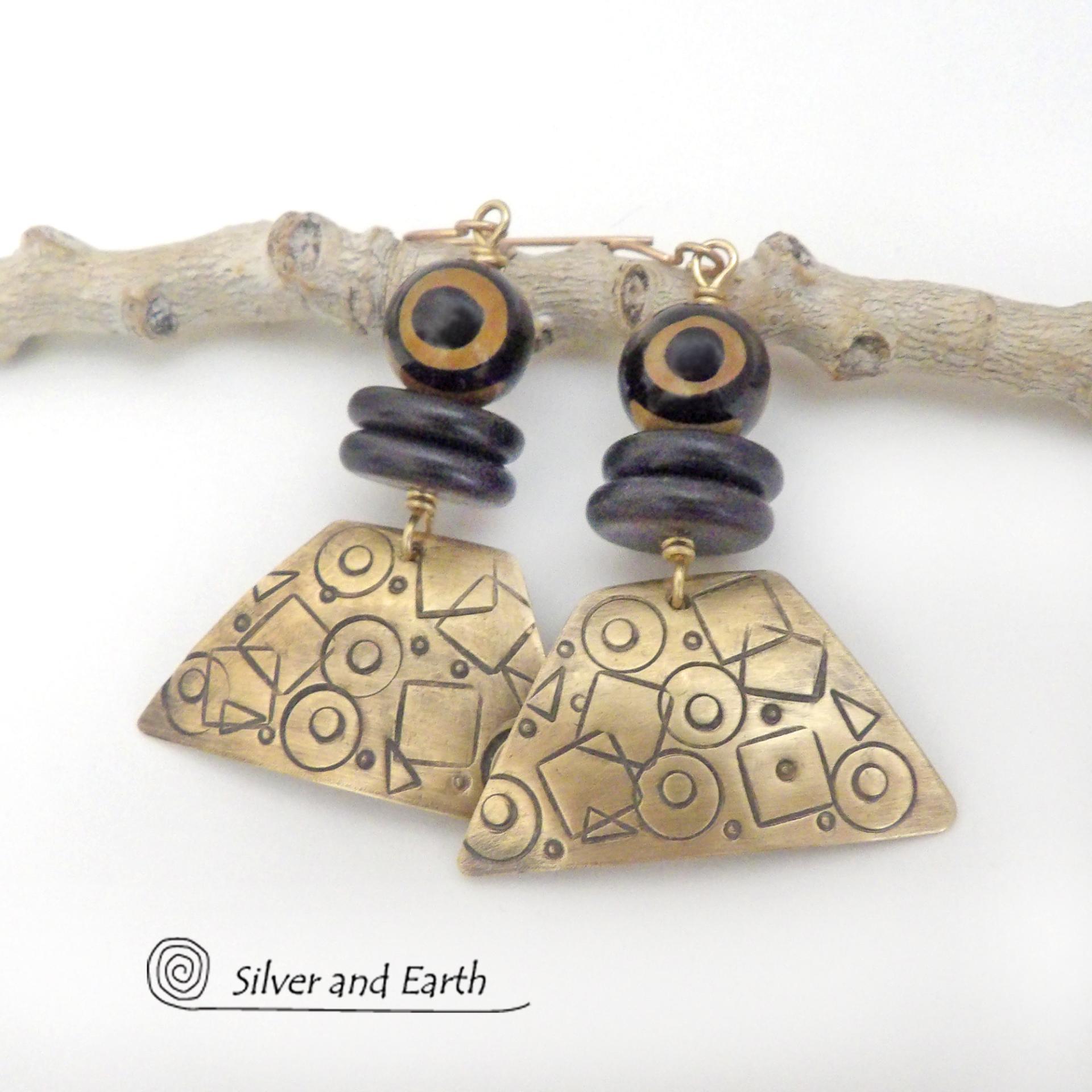 These artisan handcrafted earrings are perfect for women that love bold statement jewelry with an exotic flair. They feature gold brass dangles with an abstract hand stamped texture accented with brown and black Tibetan eye agate and black agate stones. Bold and unique - with an ethic tribal style - they'll make a striking statement.