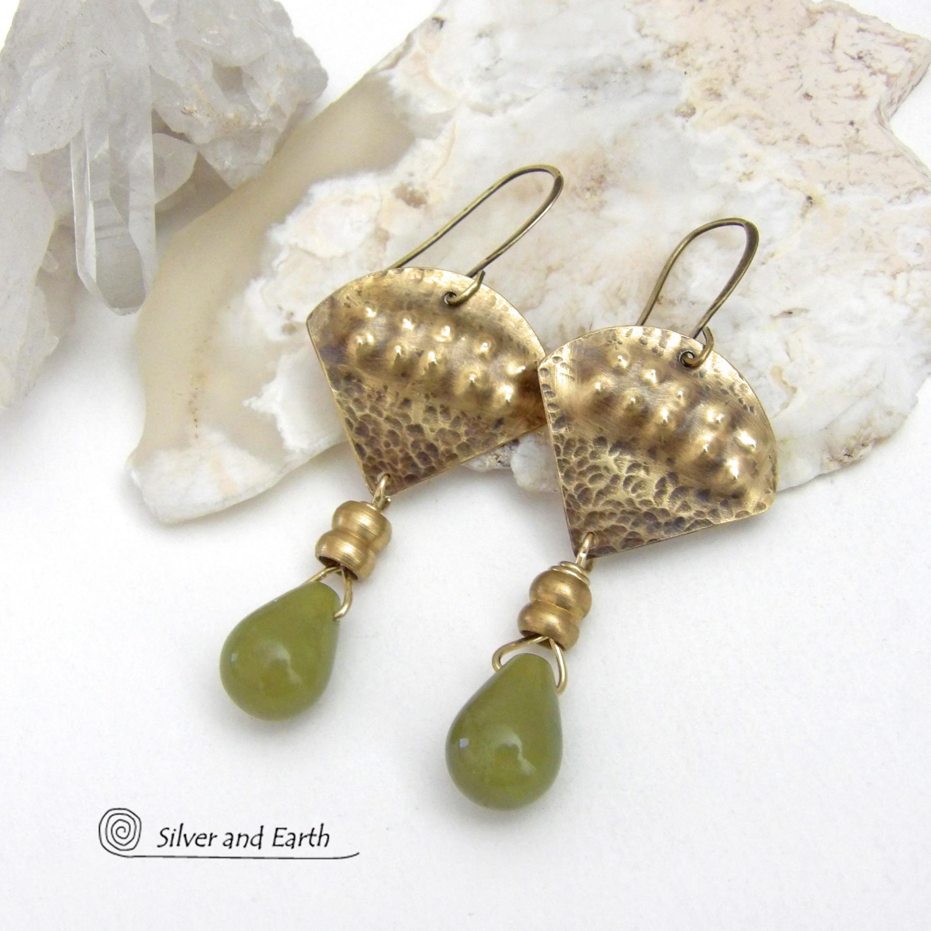 Bold and unique, these handcrafted earrings have an exotic bohemian style with a touch of Egyptian flair. They feature gold brass with a hammered and stamped texture accented with teardrop-shaped natural green jade gemstones and brass beads. Perfect for women that love to wear unique artisan handcrafted jewelry. Total length of approximately 2-3/8" from top of brass ear wires and 1" at widest point. Handmade in the USA by Silver and Earth Jewelry. 