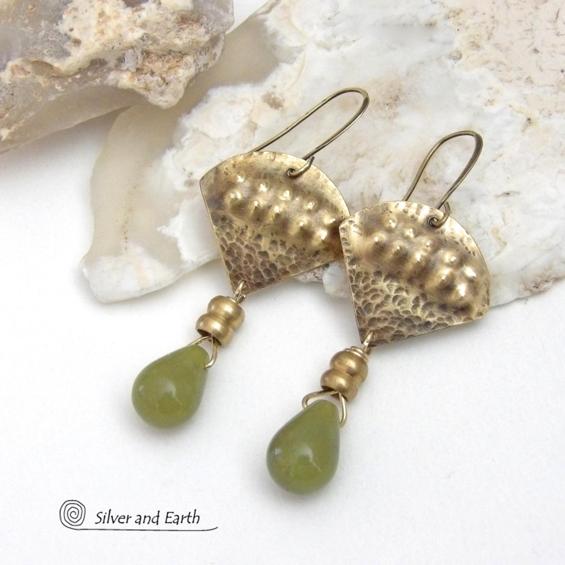 Bold and unique, these handcrafted earrings have an exotic bohemian style with a touch of Egyptian flair. They feature gold brass with a hammered and stamped texture accented with teardrop-shaped natural green jade gemstones and brass beads. Perfect for women that love to wear unique artisan handcrafted jewelry. Total length of approximately 2-3/8" from top of brass ear wires and 1" at widest point. Handmade in the USA by Silver and Earth Jewelry. 