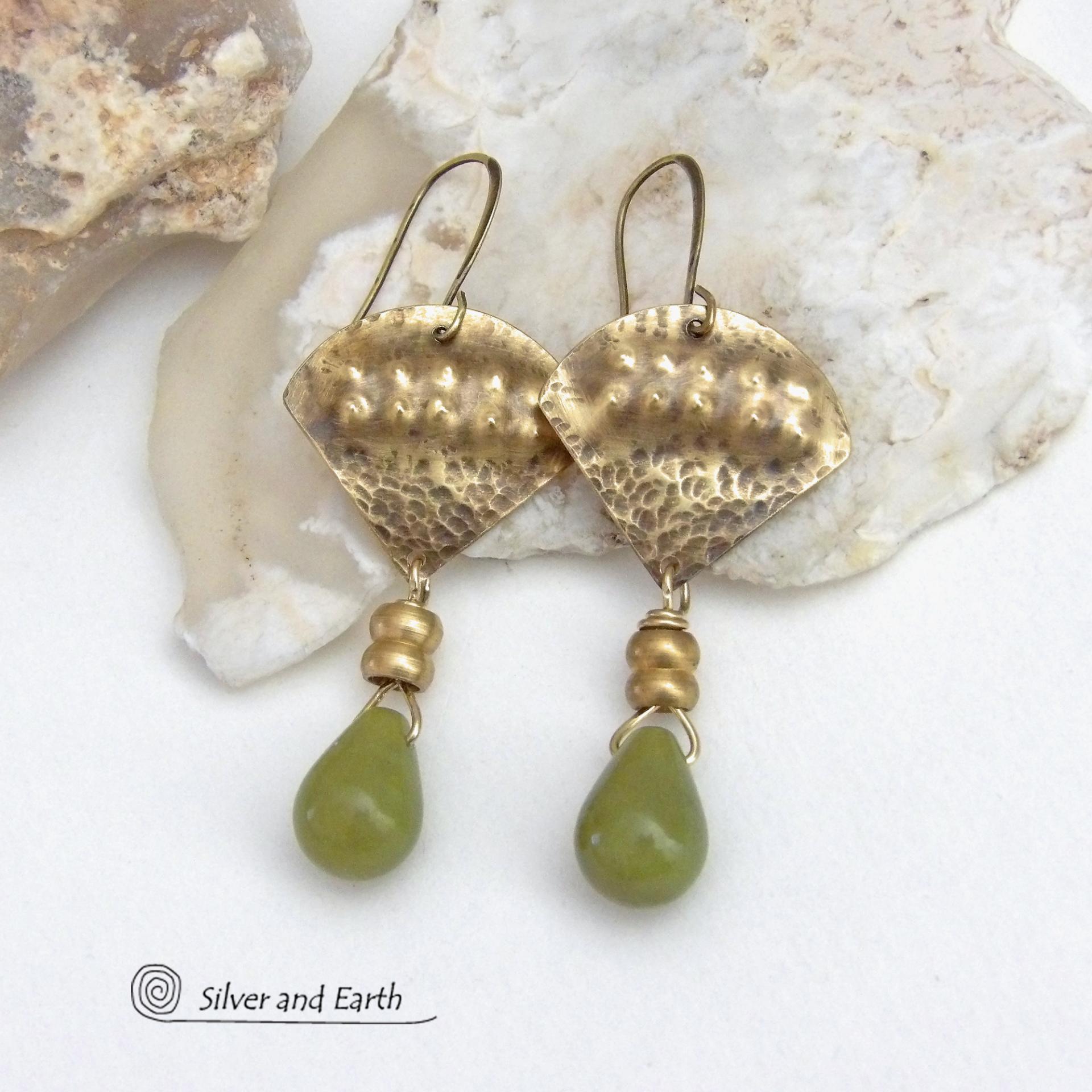 Bold and unique, these handcrafted earrings have an exotic bohemian style with a touch of Egyptian flair. They feature gold brass with a hammered and stamped texture accented with teardrop-shaped natural green jade gemstones and brass beads. Perfect for women that love to wear unique artisan handcrafted jewelry. Total length of approximately 2-3/8" from top of brass ear wires and 1" at widest point. Handmade in the USA by Silver and Earth Jewelry. 