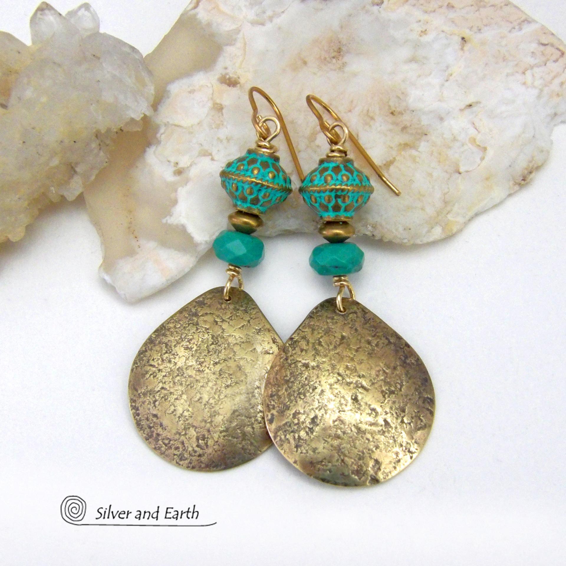 These handcrafted earrings have an elegant modern style with a tribal boho chic flair. They feature gold brass dangles with a hammered organic silky texture accented with faceted genuine turquoise gemstones, tiny brass beads and blue-green patina beads with a tribal style pattern. Bold and unique, they'll make a striking statement. Handmade in the USA by Silver and Earth Jewelry.
