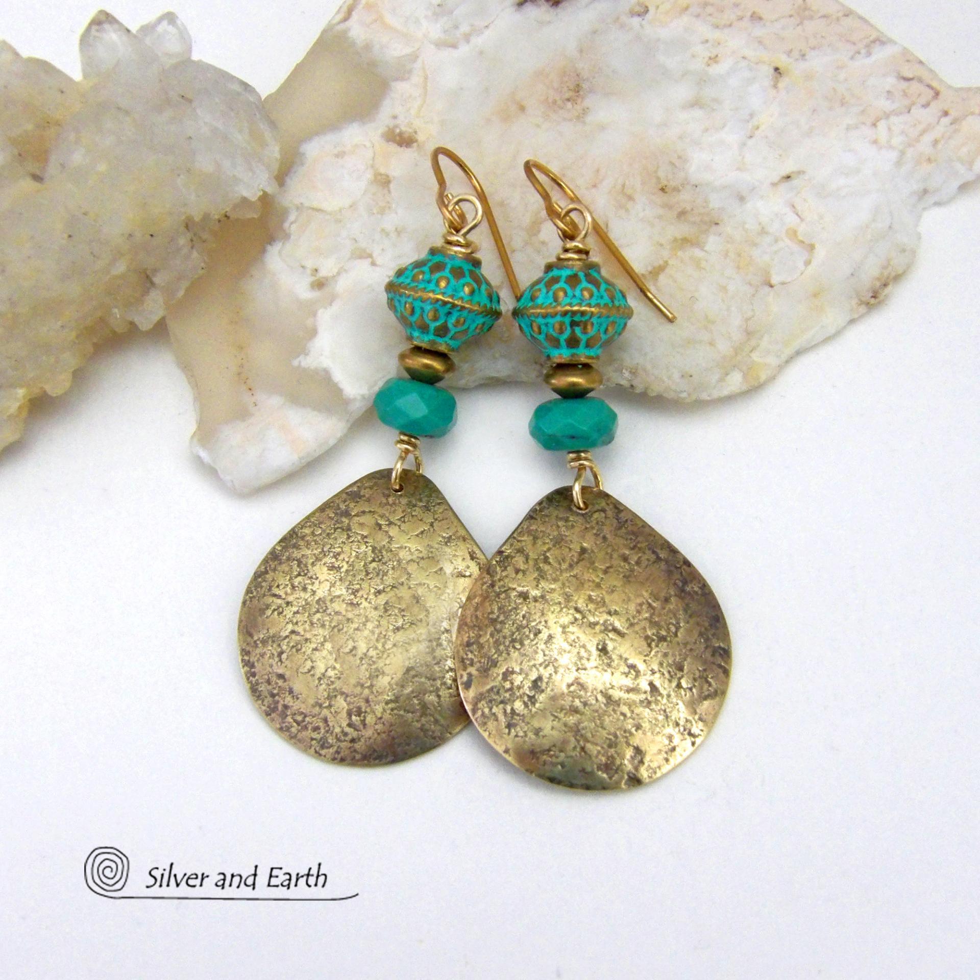 These handcrafted earrings have an elegant modern style with a tribal boho chic flair. They feature gold brass dangles with a hammered organic silky texture accented with faceted genuine turquoise gemstones, tiny brass beads and blue-green patina beads with a tribal style pattern. Bold and unique, they'll make a striking statement. Handmade in the USA by Silver and Earth Jewelry.
