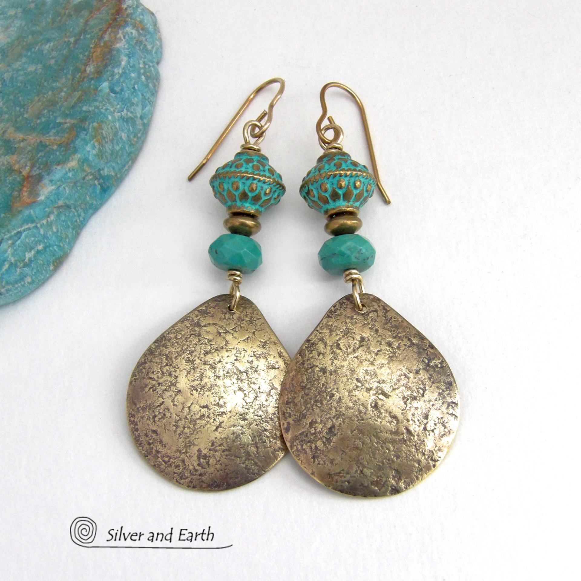 These handcrafted earrings have an elegant modern style with a tribal boho chic flair. They feature gold brass dangles with a hammered organic silky texture accented with faceted genuine turquoise gemstones, tiny brass beads and blue-green patina beads with a tribal style pattern. Bold and unique, they'll make a striking statement. Handmade in the USA by Silver and Earth Jewelry.