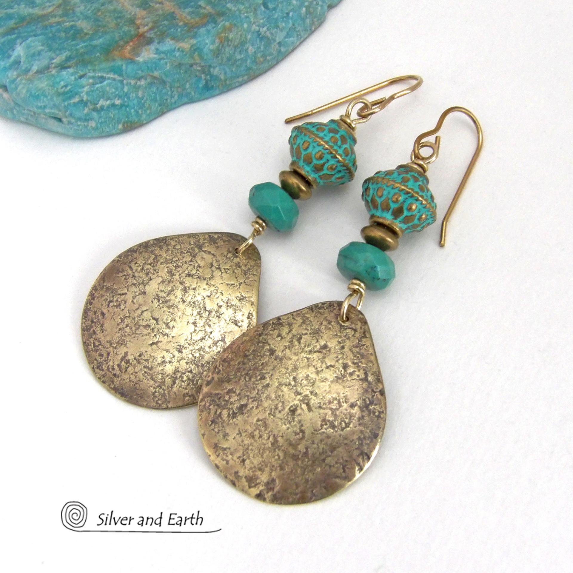 These handcrafted earrings have an elegant modern style with a tribal boho chic flair. They feature gold brass dangles with a hammered organic silky texture accented with faceted genuine turquoise gemstones, tiny brass beads and blue-green patina beads with a tribal style pattern. Bold and unique, they'll make a striking statement. Handmade in the USA by Silver and Earth Jewelry.